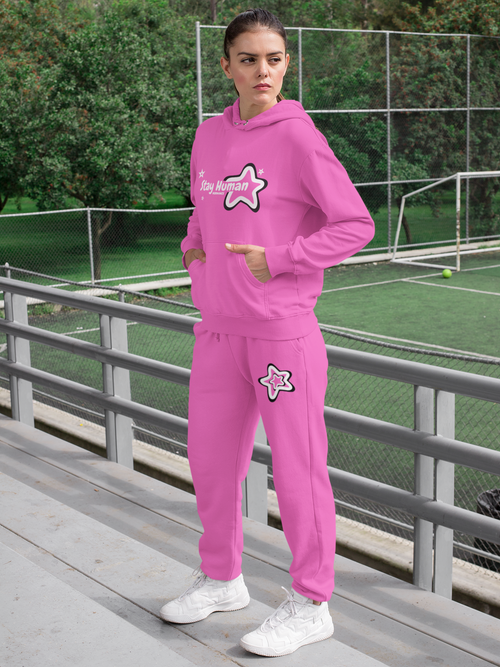 Person wearing a pink tracksuit with a logo on a sports field